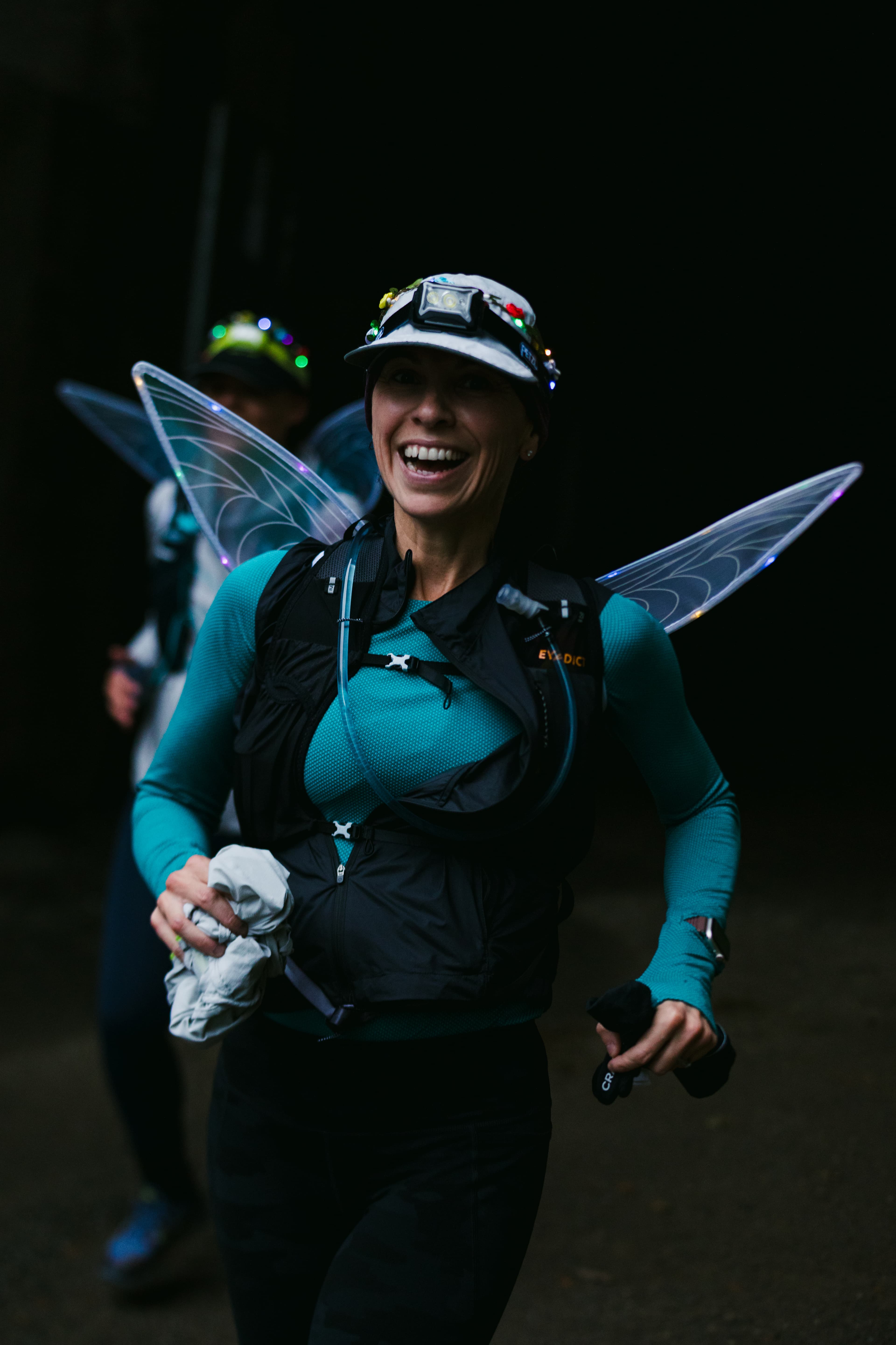 A smiling Hyak Passage runner wearing illuminated fairy wings