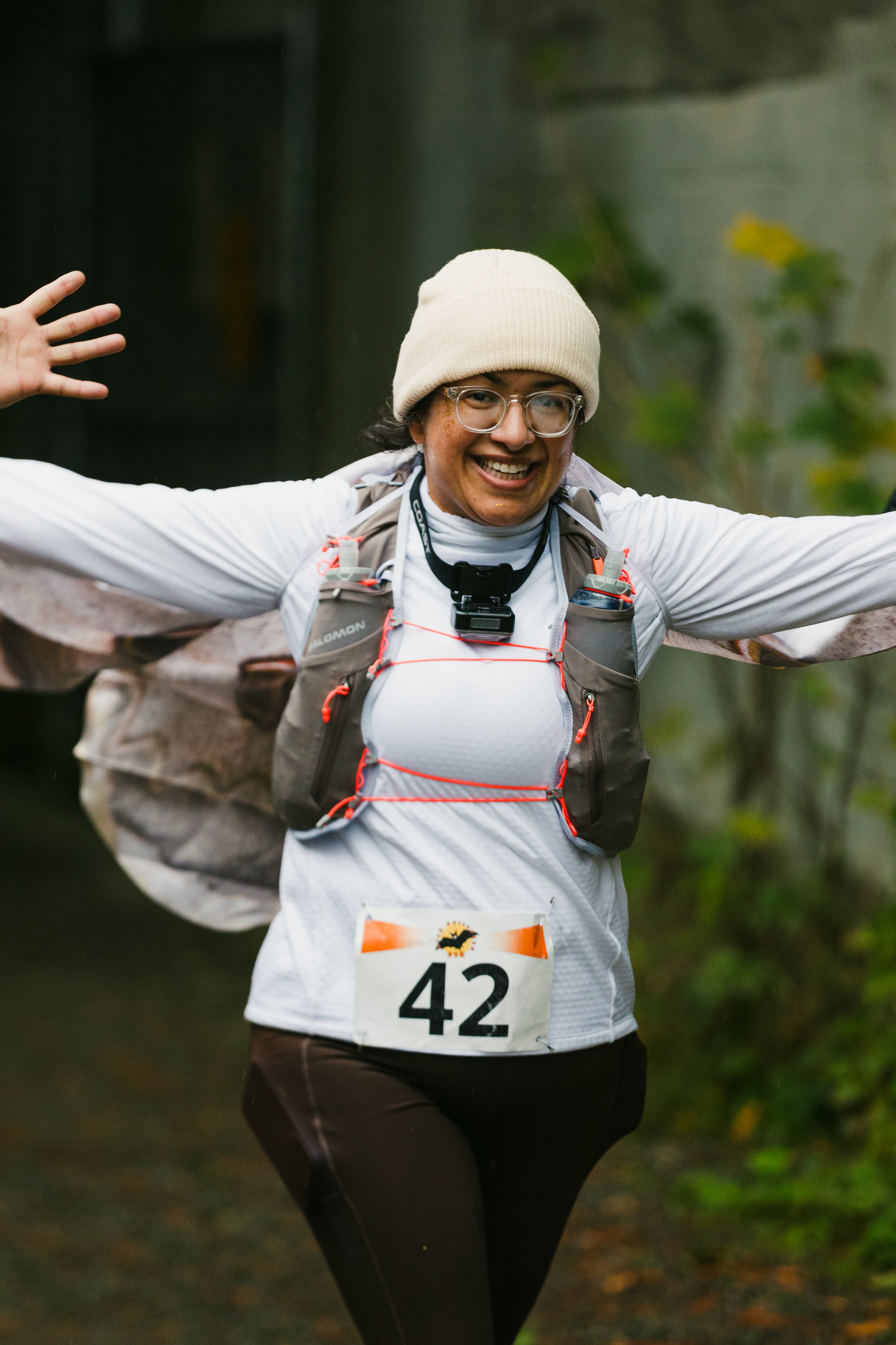 A Hyak Passage runner celebrating with her arms outstretched