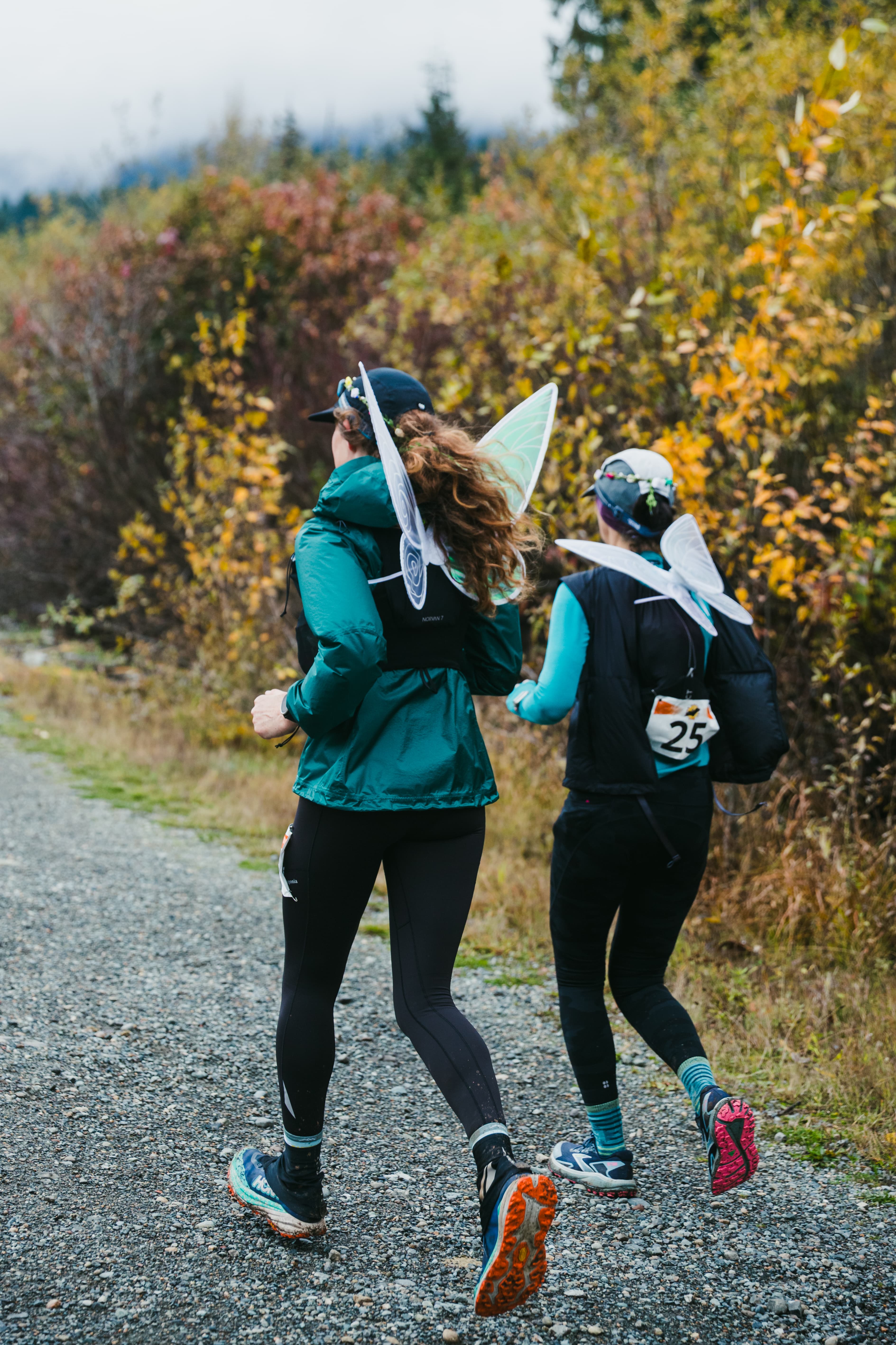 Two Hyak Passage runners in fairy costumes moving along the trail